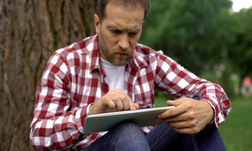 Man using online banking app on tablet, favorable terms and interest, money need